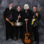 Band Photo, with Instruments, against a darker grey background